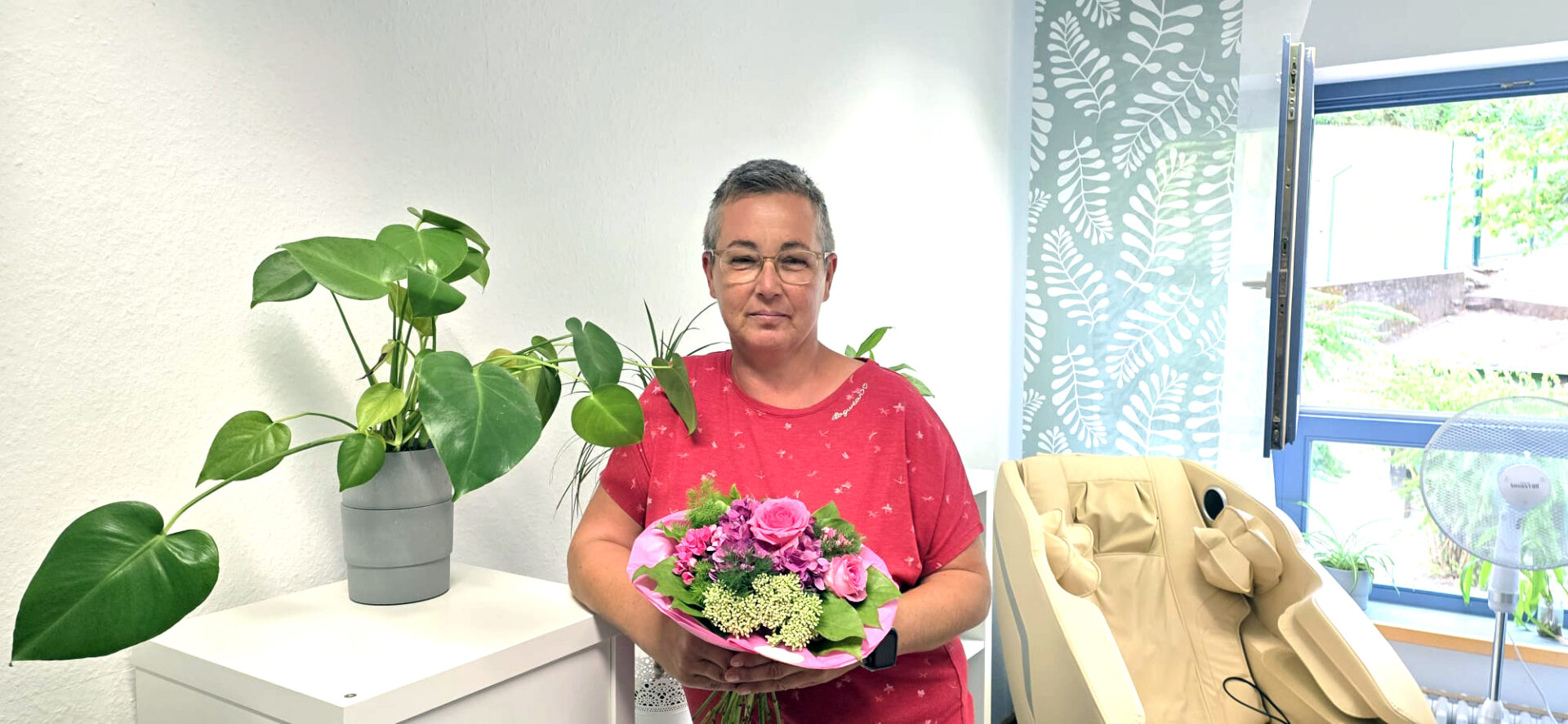 Foto der Absolventin mit Blumenstrauß